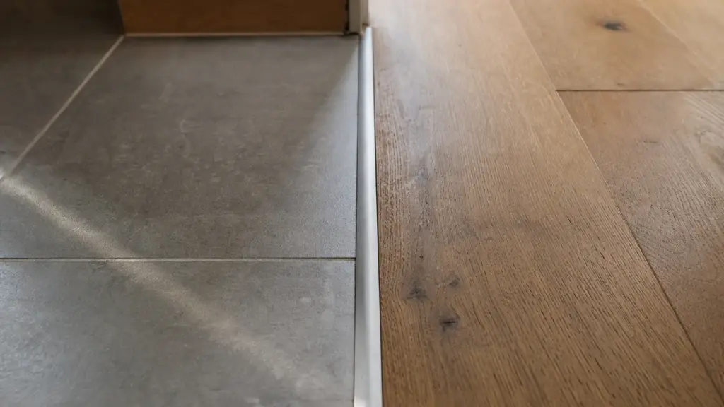 Übergang zwischen Fliesenbelag und Holzboden in einem Raum mit Fußbodenheizung