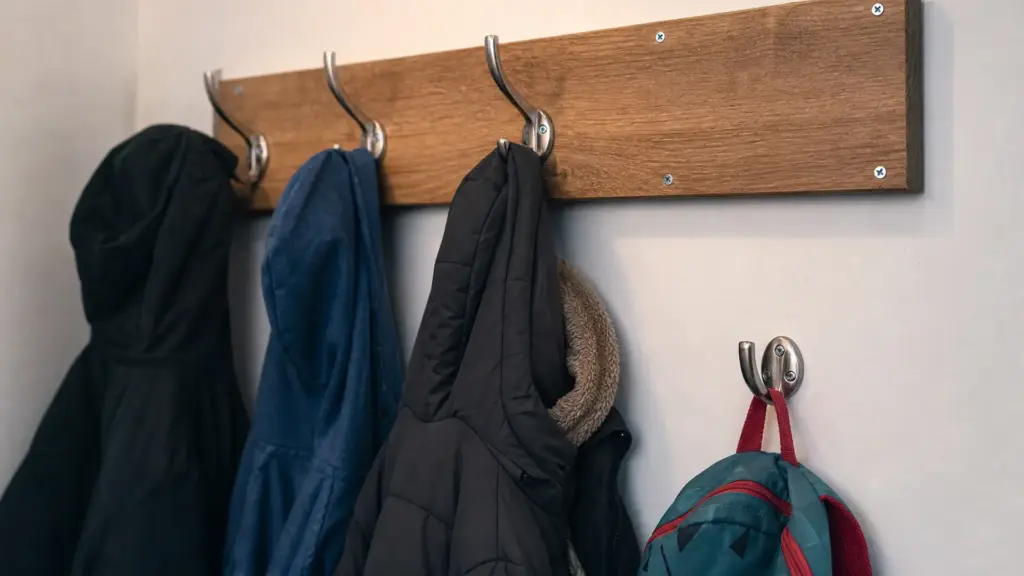 Robuste Hakenleiste an der Wand mit aufgehängten Jacken in unterschiedlicher Höhe