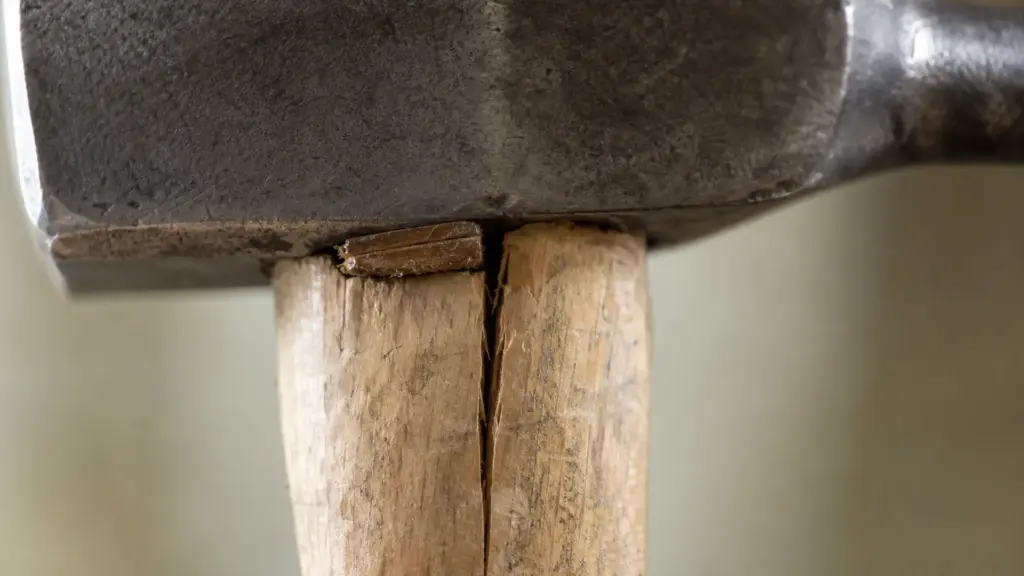 Nahaufnahme eines Hammerstiels mit sichtbarem Längsriss direkt unter dem Kopf