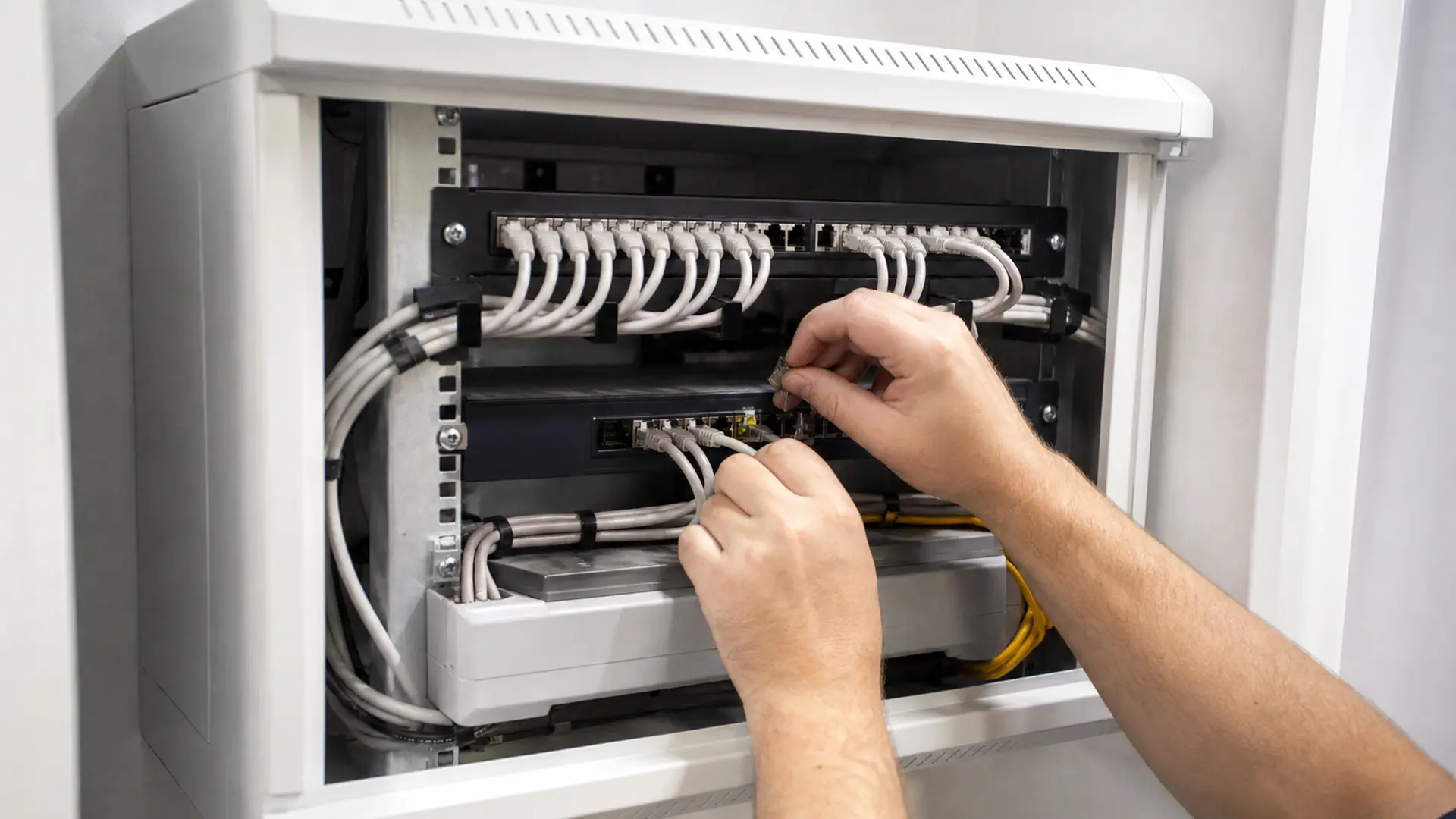 Netzwerkschrank mit Patchpanel, Switch und geordneten Patchkabeln