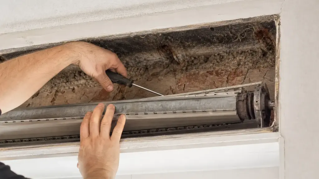 Geöffneter Rollladenkasten von innen, die ungedämmte Rückwand ist sichtbar