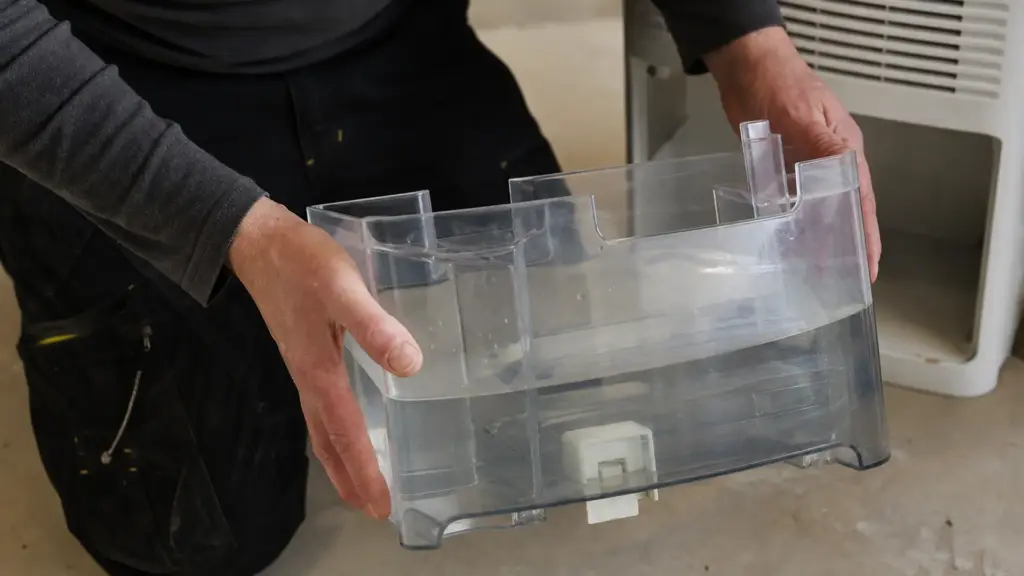Herausgezogener Wasserbehälter eines Luftentfeuchters mit deutlichem Wasserstand