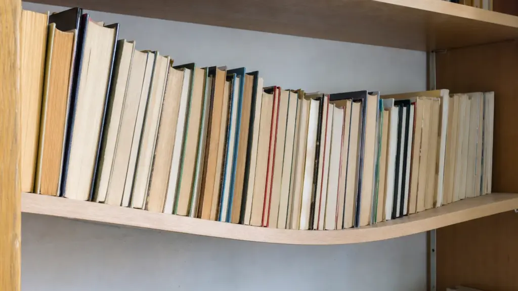 Regalboden voller Bücher biegt sich in der Mitte sichtbar durch