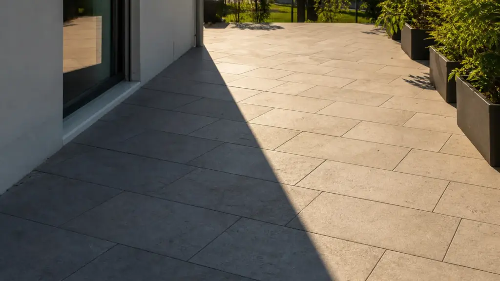 Terrasse am späten Nachmittag, der Schatten der Hauswand reicht nur über einen Teil der Fläche