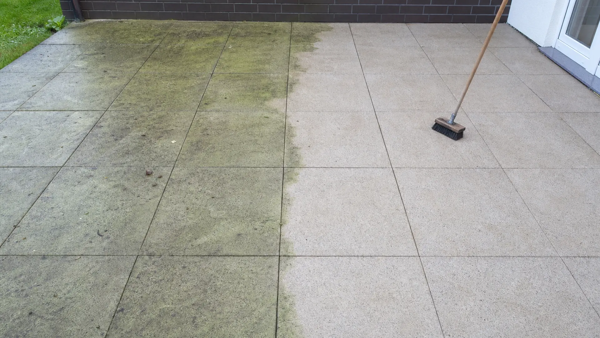 Terrassenplatten, von denen eine Hälfte grünlich belegt und die andere frisch gereinigt ist