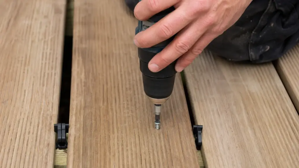 Abstandhalter zwischen zwei Terrassendielen sorgt für gleichmäßige Fugenbreite beim Verschrauben