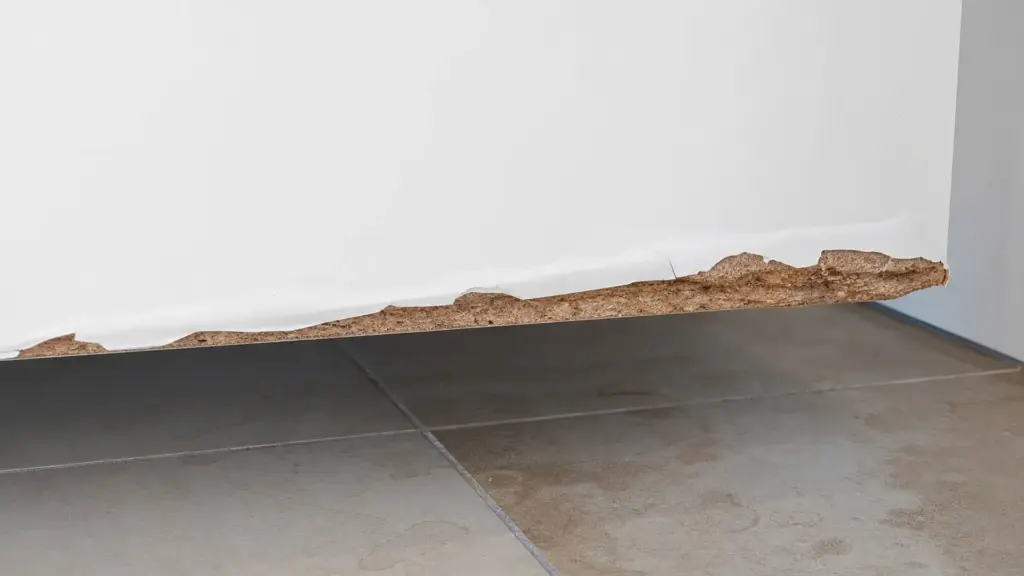 Detailaufnahme einer aufgequollenen Möbelkante unter einem Waschbecken mit abgelöster Beschichtung